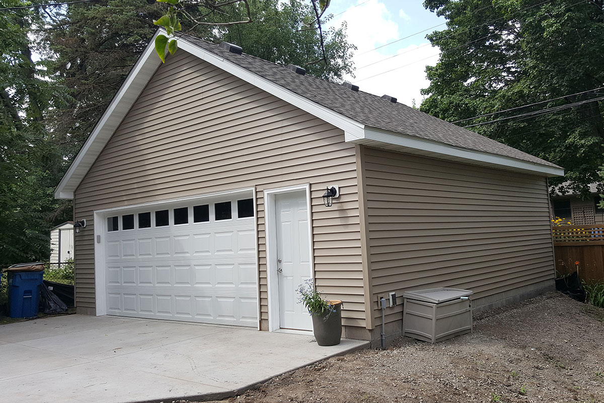 double stall garage with one main door and tan siding