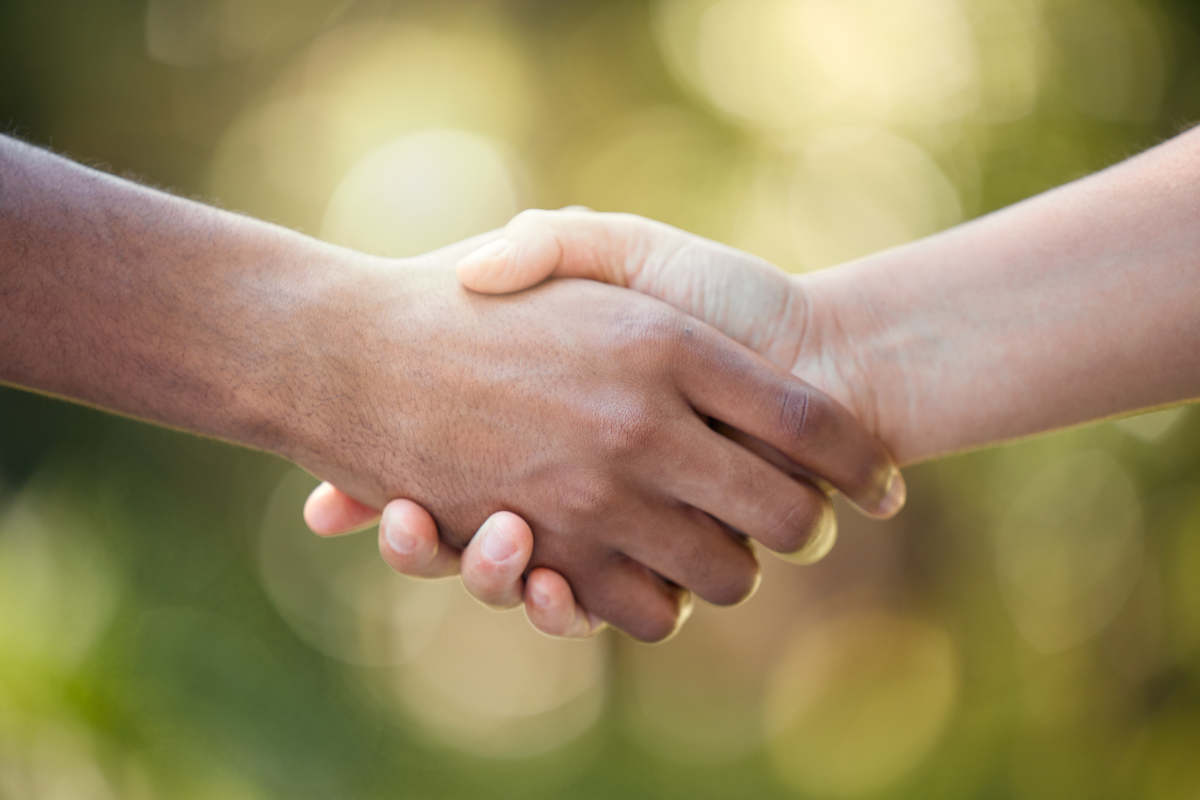 Community, handshake and support hand sign of diversity to show solidarity and trust.