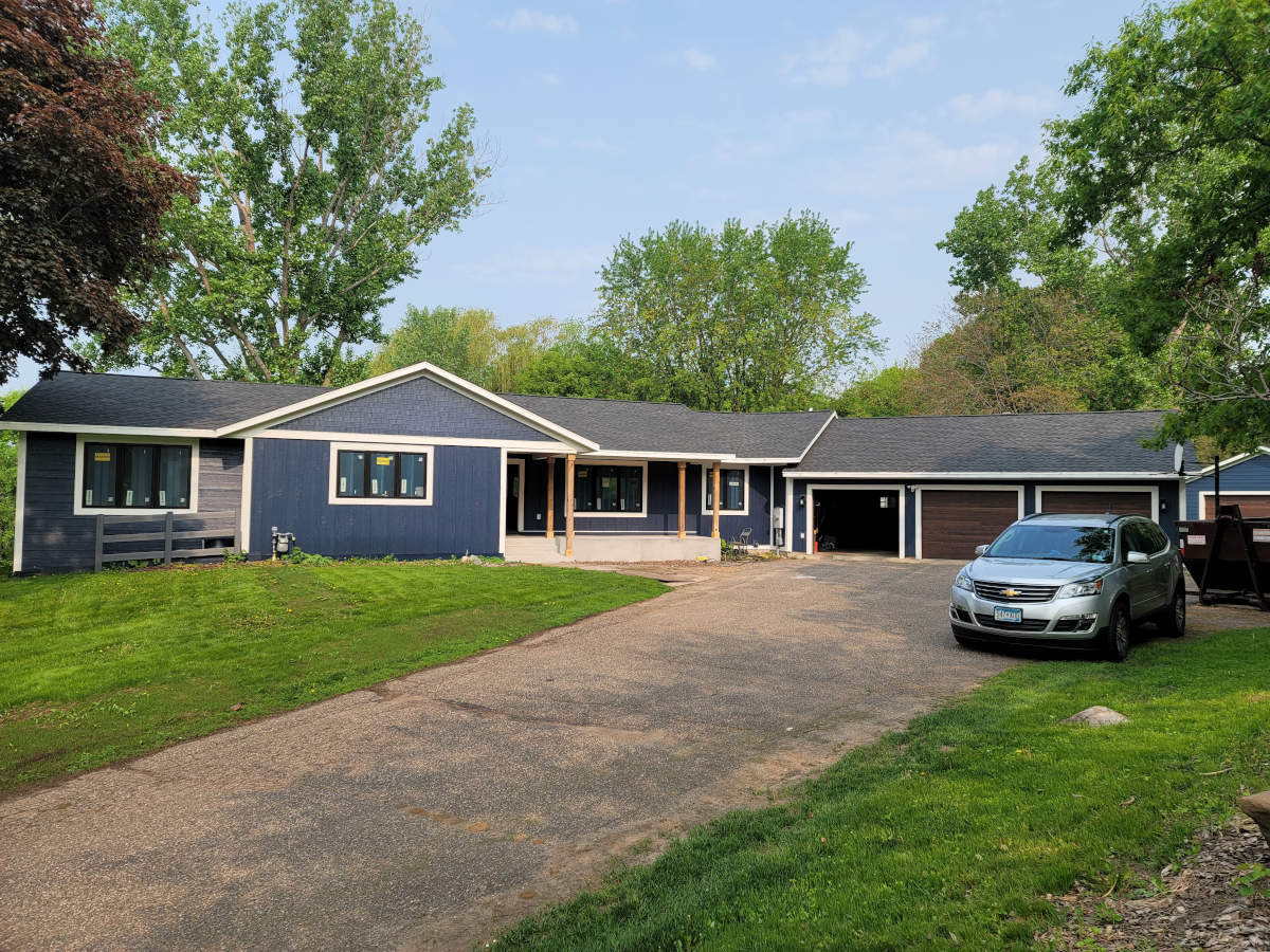 ranch style home with 3 stall garage and blue siding